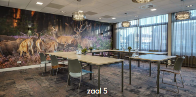 Zaal 5 van De Schakel met tafels en stoelen