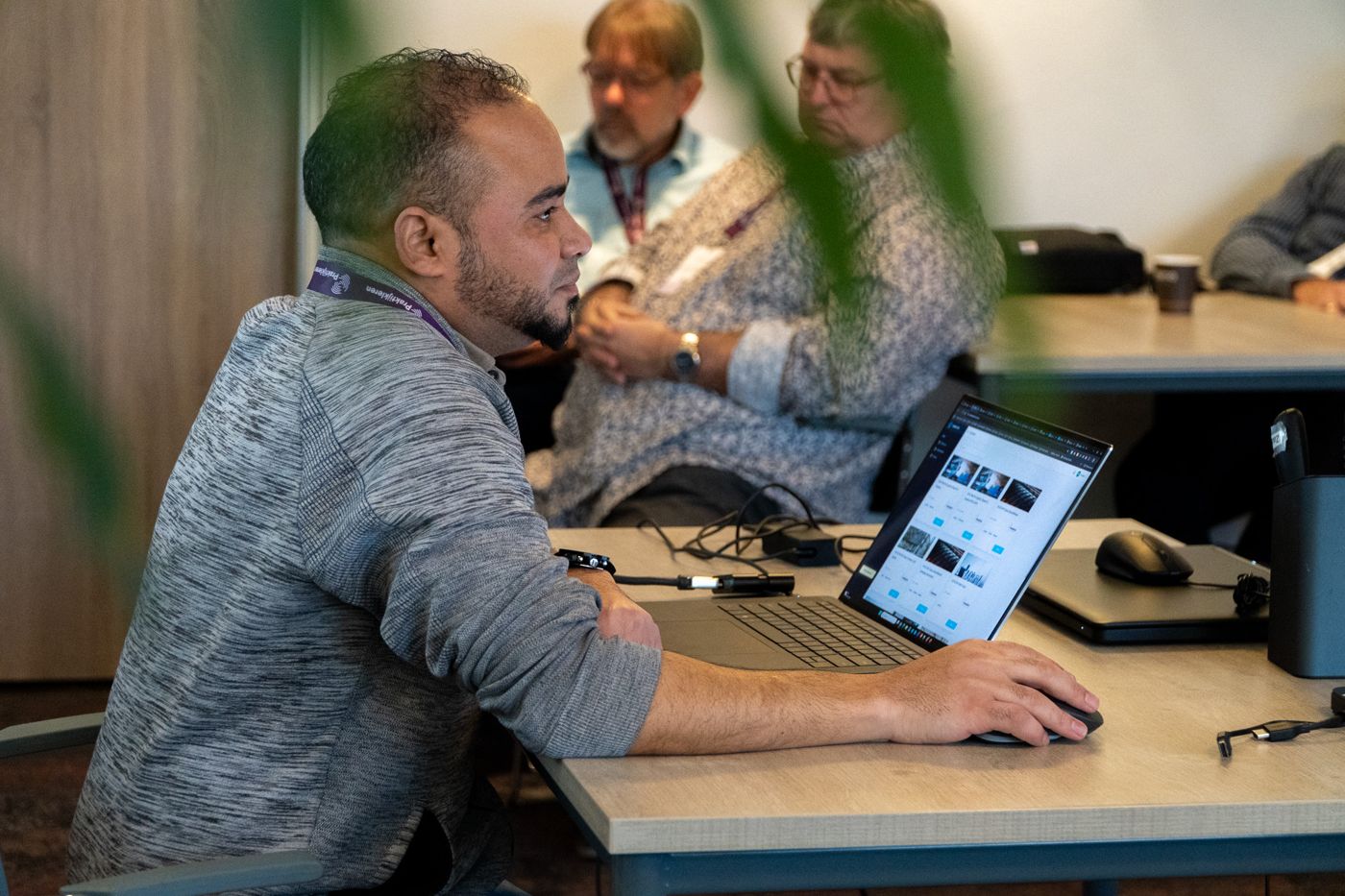 Een deelnemer werkt op zijn laptop tijdens een sessie